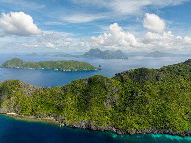 Matinloc Adası 'ndan mavi denizli Inambuyod manzarası. Mavi gökyüzü bulutları. El Nido, Filipinler.