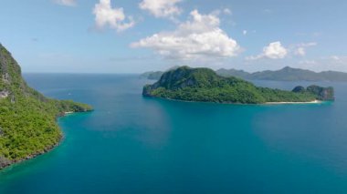 Yeşil tepeli adaları, kıyı kayaları ve plajları olan tropikal manzaralar. El Nido. Palawan, Filipinler.