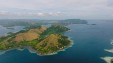 Coron 'daki Lajala' da mercanlarla çevrili kahverengi vadi ve tepelerin insansız hava aracı görüntüsü. Palawan, Filipinler.