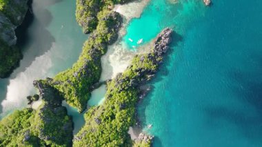 Kireçtaşı oluşumlarıyla çevrili güneş ışığı yansıtmalı tropikal göl manzarası. Miniloc Adası. El Nido, Filipinler.