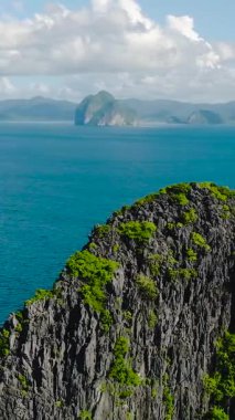 Mavi denizle çevrili ikiz kayalar. Miniloc Adası. El Nido, Filipinler. Dikey görünüm.