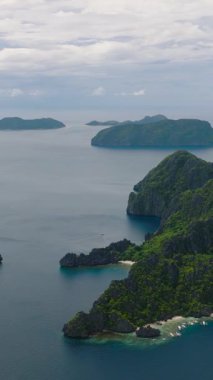 Kum plajı ve adaların üzerinde güzel kaya oluşumları. Miniloc Adası, Inatula Adası ve El Nido, Palawan 'daki Shimizu Adası. Filipinler. Dikey görünüm.