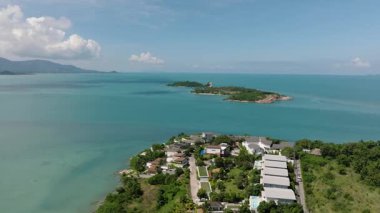 Çevresindeki modern villalar ve yemyeşil manzaralı turkuaz sularda küçük bir ada. Bo Put. Ko Samui, Tayland.