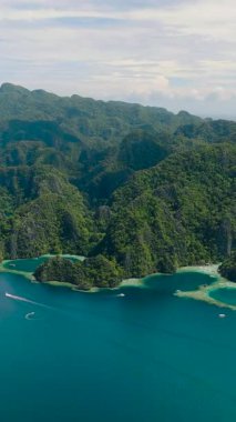 Koron, Palawan 'daki turkuaz su üzerinde tekneleri olan lagünlerin manzarası. Filipinler. Dikey görünüm.