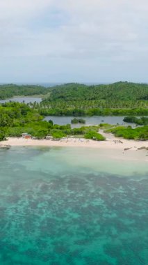 Mercan resifli gök mavisi deniz suyu. Dalgalar kumsala çarpıyor. Santa Fe, Tablas, Romblon. Filipinler. Dikey görünüm.