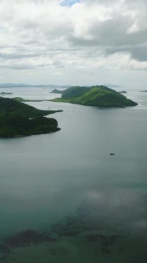 Busuanga 'daki bir grup ada. Mavi gökyüzü ve bulutlar. Palawan 'da. Filipinler. Dikey görünüm.