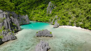 Beyaz kumlu plajlı tropik kıyı şeridi ve muhteşem kireç taşı oluşumlarıyla çevrili el değmemiş lagünler. Cadlao Adası. El Nido. Palawan, Filipinler.