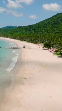 Nacpan Sahili 'nin yukarıdan görüntüsü. Mavi gökyüzü ve bulutlar. El Nido, Palawan. Filipinler. Dikey görünüm.