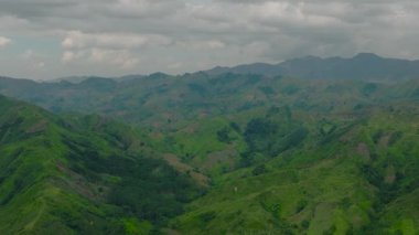 Yeşil ormanlı tropik dağ tepeleri ve tarım arazili bir dağ vadisi. Mindanao, Filipinler.