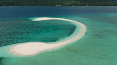 Turkuaz okyanus dalgalarıyla çevrili beyaz bir kumsalın hava aracı görüntüsü. Camiguin, Filipinler.