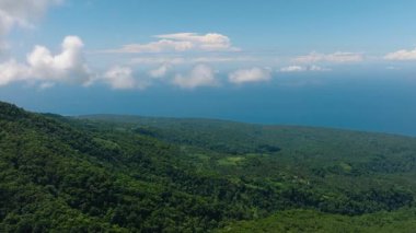 Bereketli bitki örtüsü ve ormanlı bir dağ. Mavi gökyüzü ve bulutlar. Camiguin Adası. Filipinler.