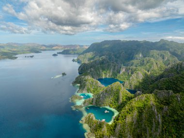 Kireçtaşı taşlı Barakuda Gölü. Mavi deniz, mavi gökyüzü ve Coron, Palawan 'da bulutlar. Filipinler.
