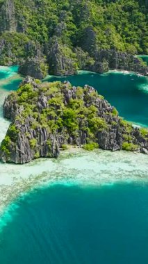 Turkuaz suyu olan ikiz göl. Gölcüklerin etrafında dolaşan tekneler. Coron, Palawan. Filipinler. Dikey görünüm.