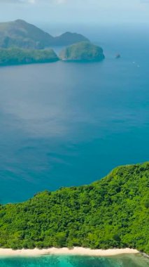 Helikopter plajındaki turkuaz deniz suyunun üzerindeki teknelerin hava görüntüsü. El Nido. Palawan, Filipinler. Dikey görünüm.