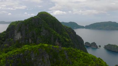 Miniloc Adası üzerindeki kireçtaşı kaya oluşumlarının ve yemyeşil çimlerin insansız hava aracı görüntüsü. El Nido, Palawan. Filipinler.