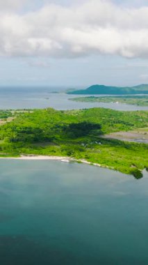 Sahili ve turkuaz deniz suyu olan bir ada. Mavi gökyüzü ve bulutlar. Looc, Tablas Adası. Romblon, Filipinler. Dikey görünüm.