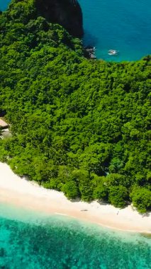 Helikopter plajı ve turist botları. Turkuaz deniz suyunun üzerinde güneş yansıması. El Nido. Palawan, Filipinler. Dikey görünüm.