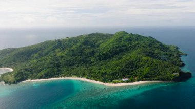 Berrak mavi sularla çevrili, yemyeşil tepeler ve beyaz kumlu plajlarla kaplı tropikal bir ada. Romblon, Filipinler 'deki Cobrador Adası.