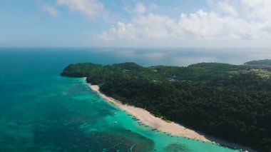 Turkuaz berrak su, kayıklar ve beyaz kumda dalgalar. Puka Deniz Kabuğu Sahili. Boracay, Filipinler.