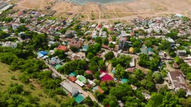 Konut alanının üzerinde uçuyor, Coron 'daki ticari binalar. Filipinler, Palawan 'daki sahil şehri.