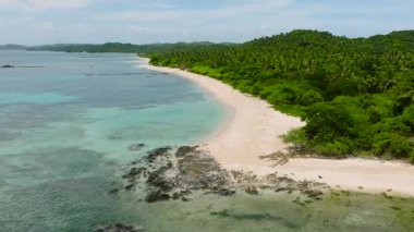 Rocky plajı ve sahil şeridindeki beyaz kumlarda dalgalar. Santa Fe, Tablas, Romblon. Filipinler.