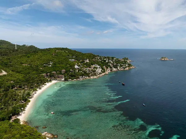 Turkuaz suyu ve yeşil tepeleri olan manzaralı kumlu bir sahil. Tayland, Koh Tao.