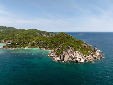 Etrafı yemyeşil tepeler ve dağınık teknelerle çevrili turkuaz suyu olan geniş tropikal koylar. Koh Tao, Tayland.