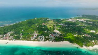 Yeşil bitki örtüsü ve beyaz kumlarla dolu verimli bir tropikal kıyı şeridi yakınında şeffaf turkuaz sular. Boracay Adası, Filipinler.