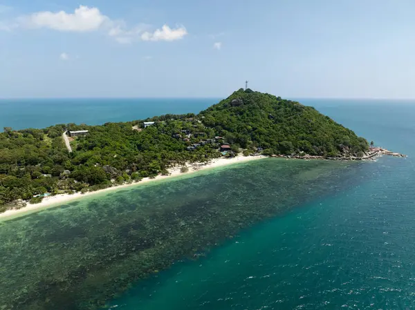 Bereketli yeşilliklerle kaplı manzaralı bir tepe ve turkuaz deniz manzaralı evler. Leela Sahili. Ko Pha Ngan, Tayland.