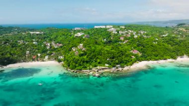 Sahil şeridine doğru yuvarlanan yeşil tepeler berrak turkuaz sularla kaplı. Boracay Adası, Filipinler.