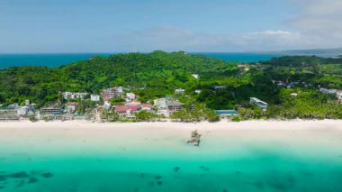 Beyaz kumlu sahilleri, turkuaz suları ve canlı yeşillikleri olan bir sahil manzarası. Boracay Adası, Filipinler.