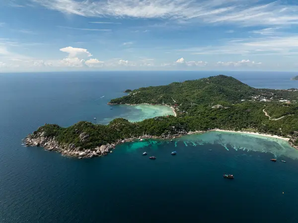 Bereketli yeşil tepeler ve durgun turkuaz sularla çevrili kayalık kıyı şeritleriyle sakin bir koy. Tayland, Koh Tao.