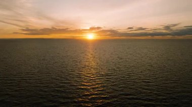 Altın renklerin havadan görünüşü, güneş ufukta batarken sakin açık okyanusu yansıtır. Koh Tao, Tayland.