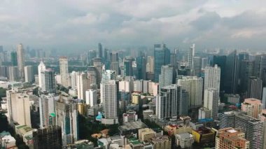 Açık gökyüzü ve kentsel canlılığa sahip, yoğun, modern bir şehirde yüksek binaların manzarası. Metro Manila, Filipinler.
