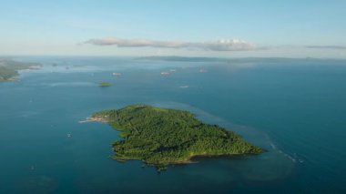 Mavi deniz ve mercan resifleriyle çevrili adanın insansız hava aracı görüntüsü. Mindanao, Filipinler.