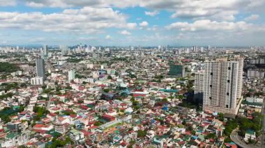 Renkli evleri ve modern gökdelenleri olan banliyö bölgelerinin havadan görünüşü. Metro Manila, Filipinler.