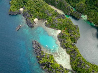Miniloc Adası 'ndaki Small Lagoon' da turkuaz su üzerinde kano. El Nido, Palawan. Filipinler.