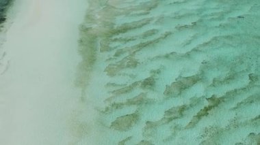 Turkuaz deniz suyu ve beyaz kum okyanus tabanı. Tekneleri ve dalgaları olan bir kum yığını. Surigao del Sur, Filipinler.