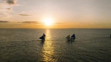 Yelkenlilerin ve denizlerin üzerinde bulutlu gün batımı. Boracay, Filipinler.