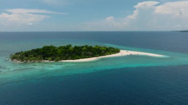 Kum çubuğu ve yeşil ağaçları olan küçük bir ada. Mantigue Adası 'nda gök mavisi su ve mercan resifleri var. Camiguin, Filipinler.