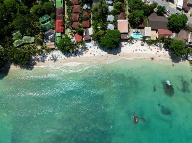 Palmiye ağaçları ve turkuaz sularla çevrili kumlu plajların ve tatil yerlerinin üst manzarası. Koh Samui, Tayland.