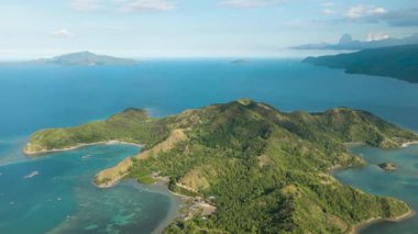 Kıyı şeridinde gök mavisi suyu ve mercanları olan tropik bir ada. Uyuyan Dinozor. Mati, Davao Oriental. Filipinler.