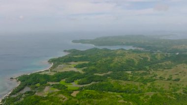 Beyaz kum ve mercanlarla dolu bir sahil şeridi. Santa Fe, Tablas, Romblon 'daki dağ tepeleri ve pirinç tarlaları. Filipinler.