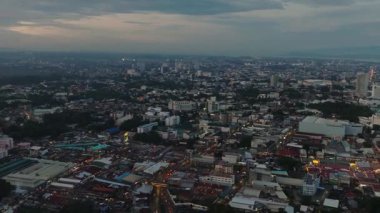 Gün batımında ışıldayan ışıklarla dolu bir yerleşim yeri. Davao Şehri. Mindanao, Filipinler.