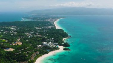 Kıyı şeridinde dalgalar ve turkuaz berrak suyla kumsalın insansız hava aracı görüntüsü. Boracay, Filipinler.