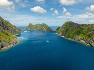 Dalgalarla mavi denizi aşan bir tekne. Tapiutan ve Matinloc. El Nido, Palawan. Filipinler.