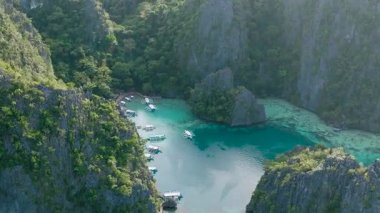 Kayangan Gölü etrafındaki kireçtaşı dağlarının insansız hava aracı görüntüsü. Sahilde ada turu yapan tekneler. Coron, Palawan. Filipinler.