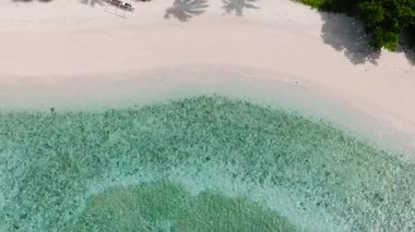 Cobrador Adası 'ndaki beyaz kumlu sahildeki okyanus dalgaları üzerinde güneş yansıması. Romblon, Filipinler.