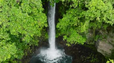 Camiguin Adası 'nda yemyeşil yapraklarla çevrili bir şelale. Tuasan Şelalesi. Filipinler.