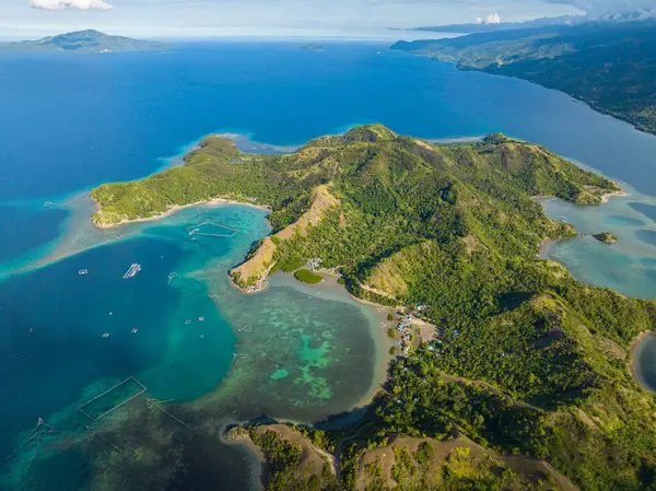 Tropik ada, gök mavisi su mercan kayalıklarını ve mercan adalarını çevreledi. Uyuyan Dinozor Adası. Mati, Davao Oriental. Filipinler.